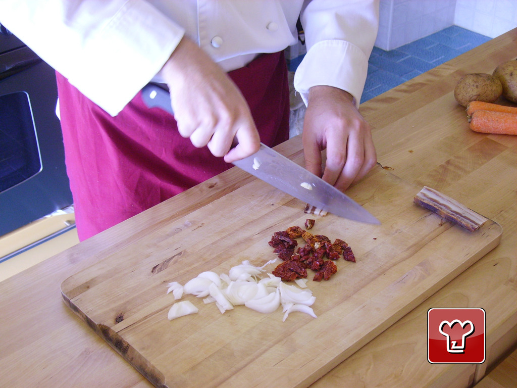Tagliare a pezzetti il pomodoro secco e a fette la cipolla.