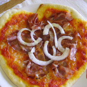 Pizza mit Capocollo-Wurst und Zwiebeln